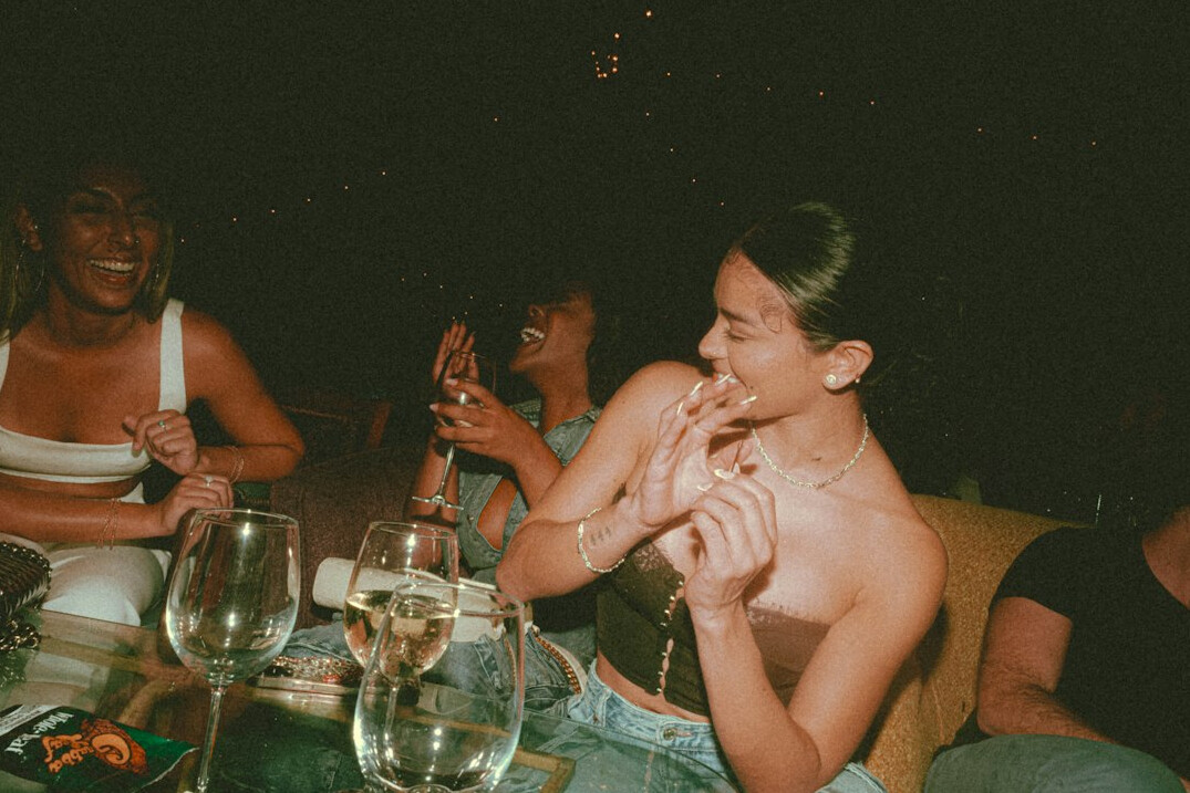 Group of friends laughing together around a table