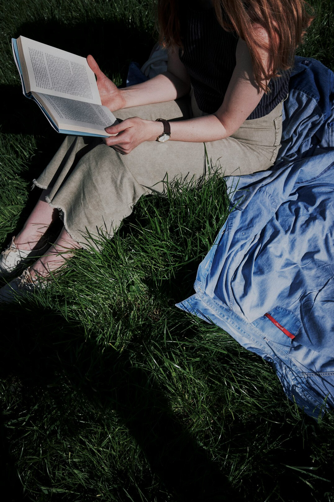 person reading book outdoors