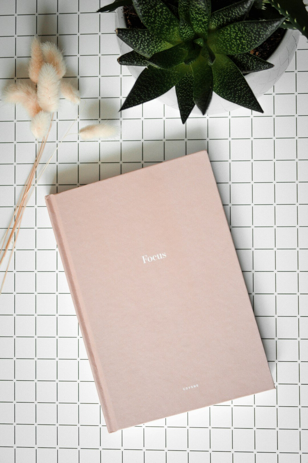 Planner and pen on a desk with a cup of coffee